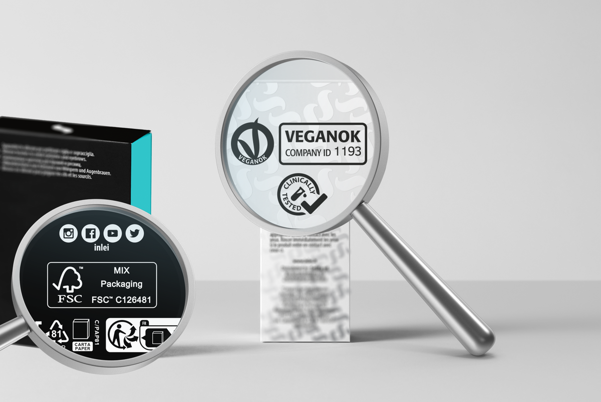 Lupen zeigen die VEGANOK-Zertifizierung (Company ID 1193) und das FSC-Siegel auf der Verpackung von InLei® Lash Filler 25.9